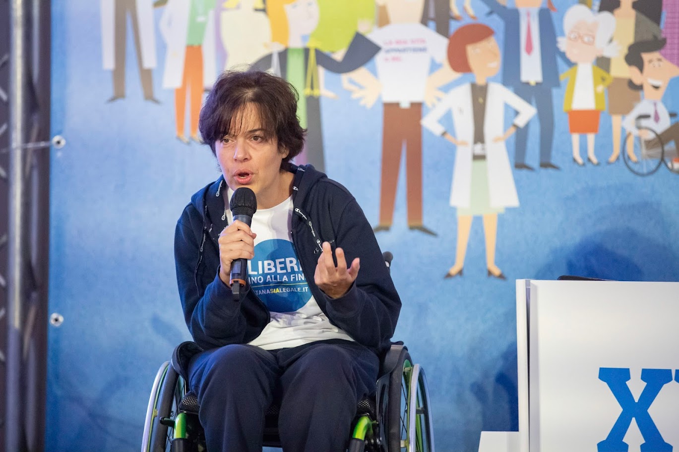 Laura prende la parola al microfono durante un incontro pubblico
